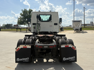 Rear view of a Mack AN64T tractor truck chassis showing dual rear wheels and mud flaps with Bruchner's Truck Equipment branding.