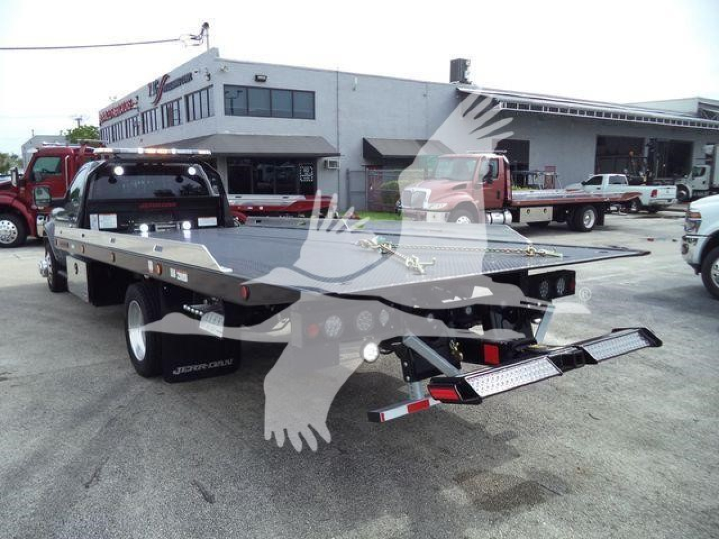 Ram 5500 rollback tow truck flatbed showing rear view with bumper ramps and dual wheel setup.