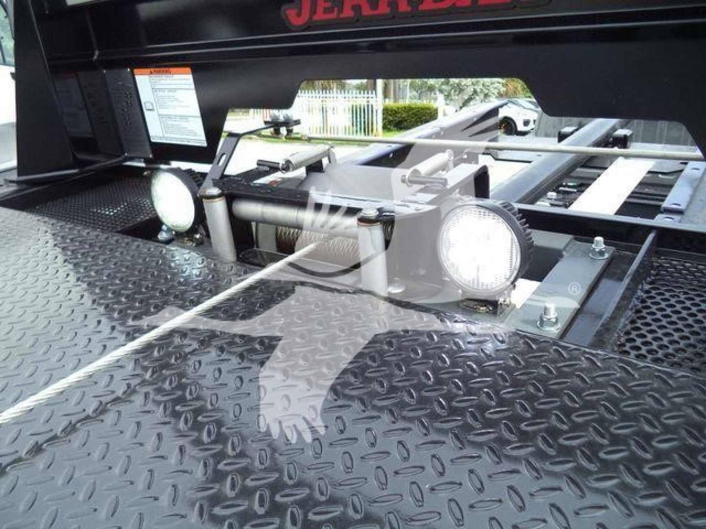 Ram 5500 rollback equipment showing diamond plate deck and two round work lights with mounting hardware.