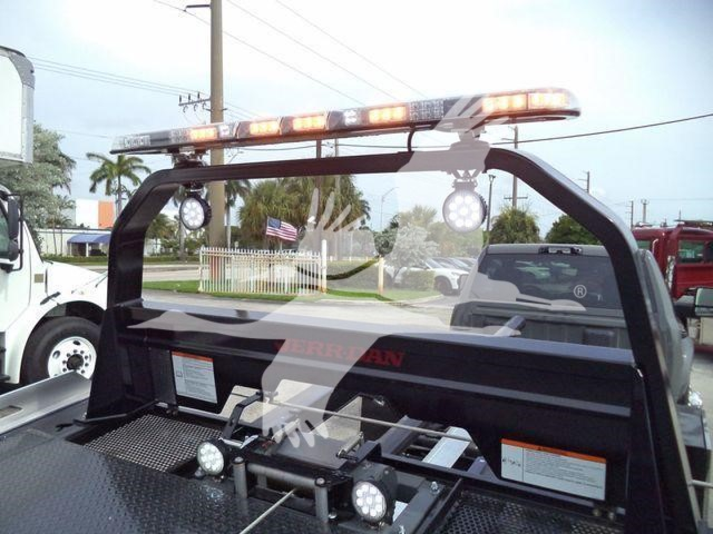 Truck rollback bed with roof light bar and working area; text not clearly readable in this image