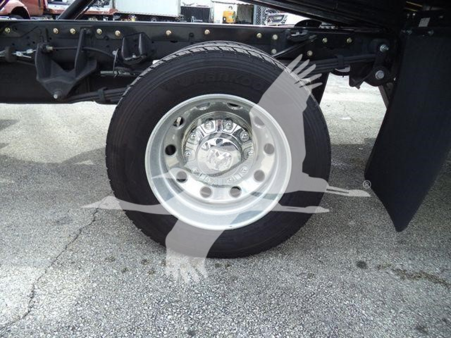 Ram 5500 wheel and front suspension showing tire and steel rim with hubcap, undercarriage components visible in the background.