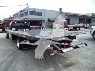 Ram 5500 rollback tow truck flatbed showing rear view with bumper ramps and dual wheel setup.