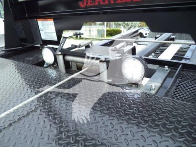 Ram 5500 rollback equipment showing diamond plate deck and two round work lights with mounting hardware.
