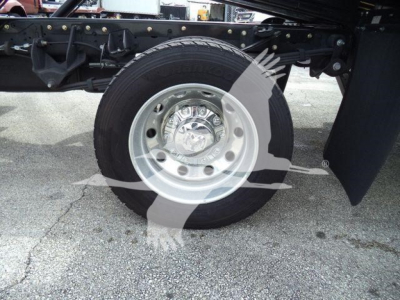 Ram 5500 wheel and front suspension showing tire and steel rim with hubcap, undercarriage components visible in the background.