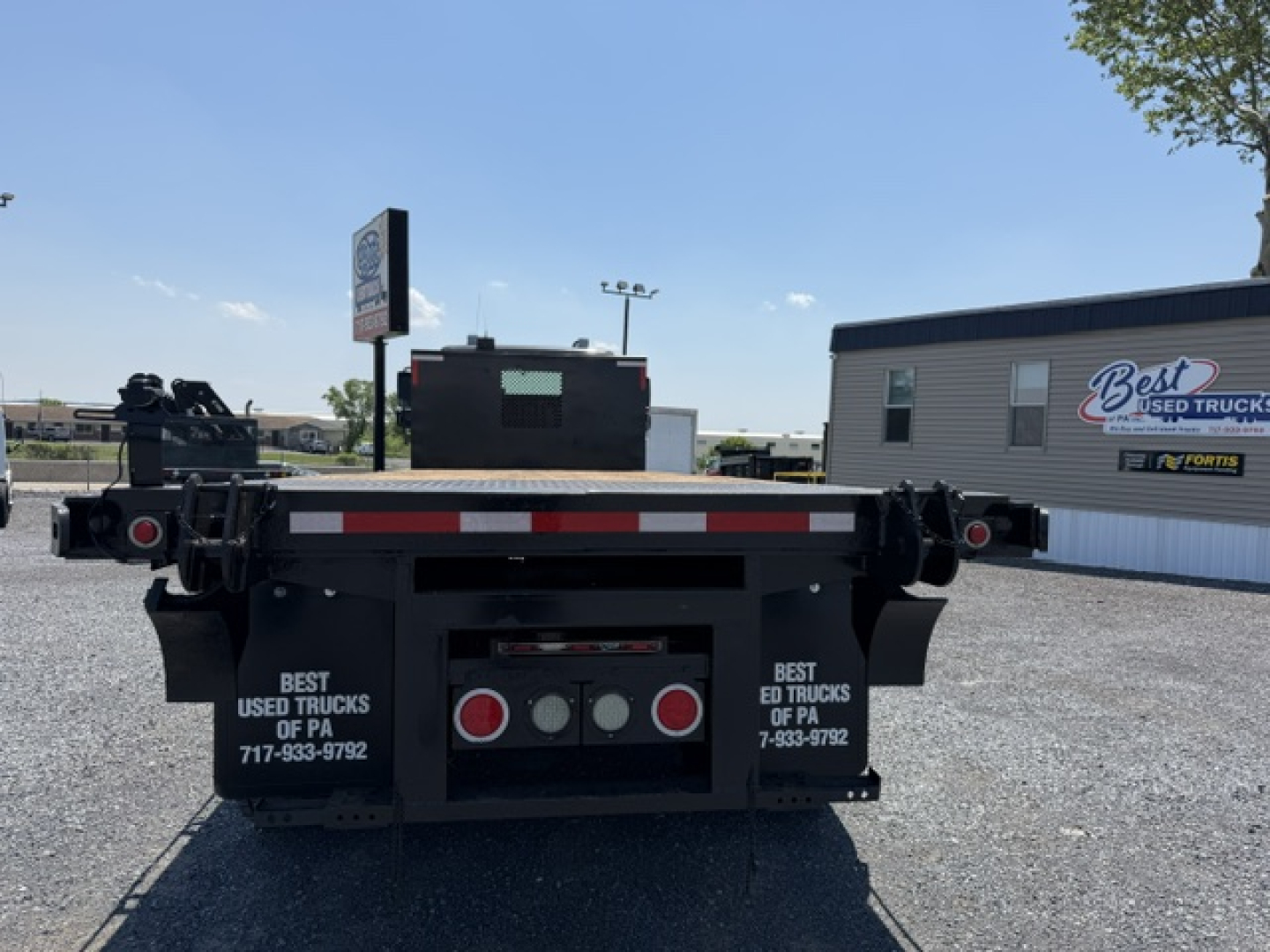 Freightliner M2-112 flatbed truck rear view showing taillights and mudflaps with Best Used Trucks of PA branding.