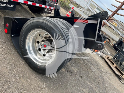 Rear flip trailer axle with dual tires on aluminum rim, black frame, hydraulic components, part of Fontaine lowboy trailer.