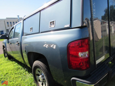 Chevrolet Silverado 1500 pickup truck 4x4 in blue with utility bed cap showing 4x4 badge and rear taillight