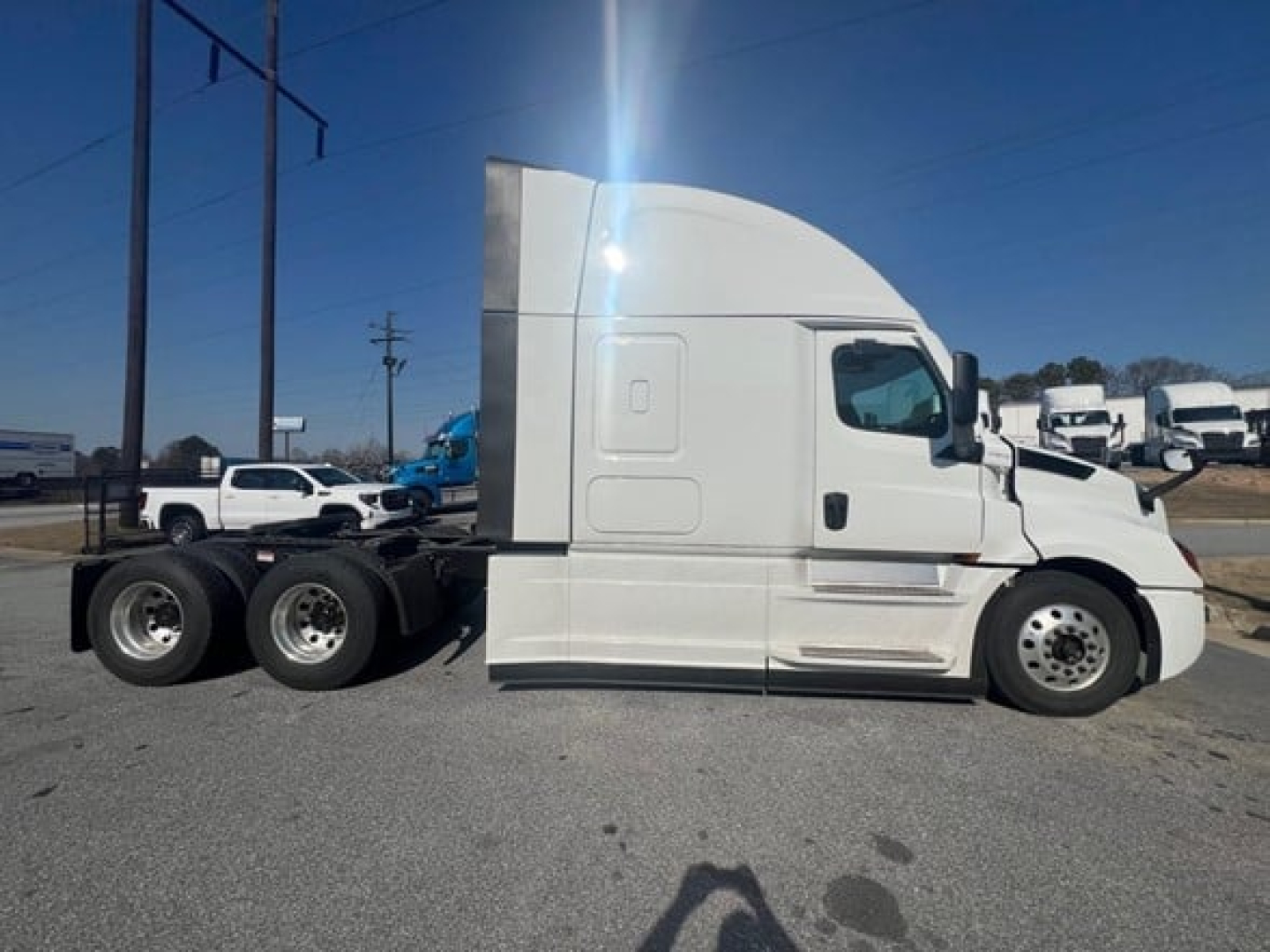 Truck side view of a white Freightliner Cascadia 126 conventional sleeper tractor with dual rear axles, showing the cab and sleeper, no visible text on the body.