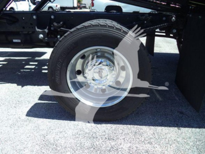 Ford F-Series truck chassis with wheel and tire, showing steel rim and hub, part of a rollback truck setup.