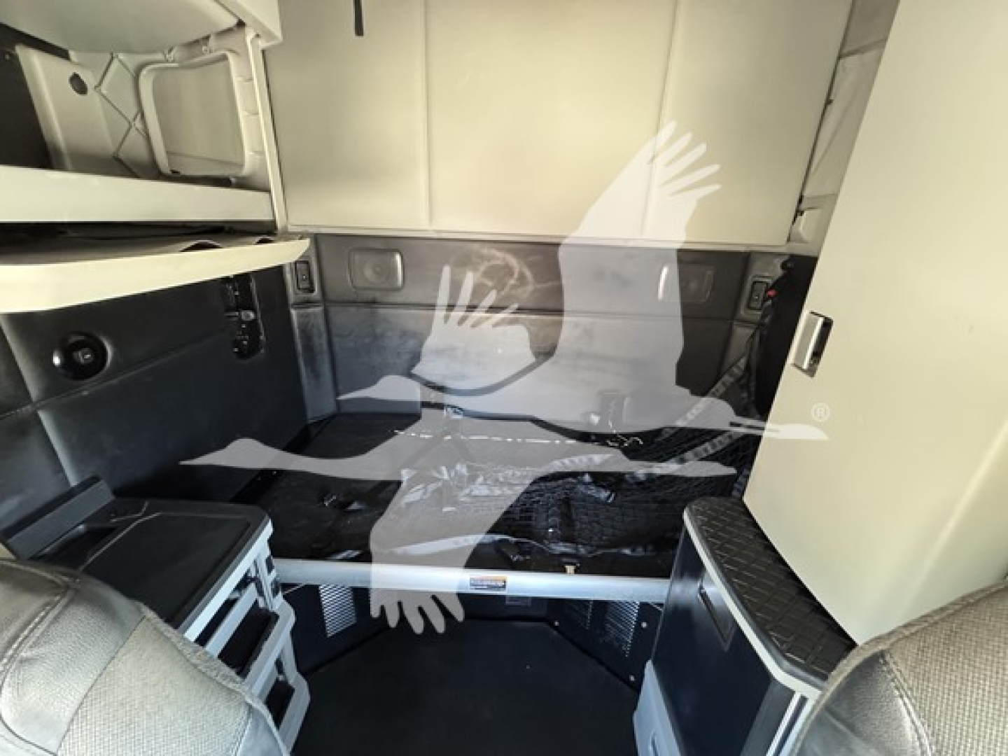 Kenworth T680 truck sleeper cab interior view showing storage compartments and raised decking with exposed framing.