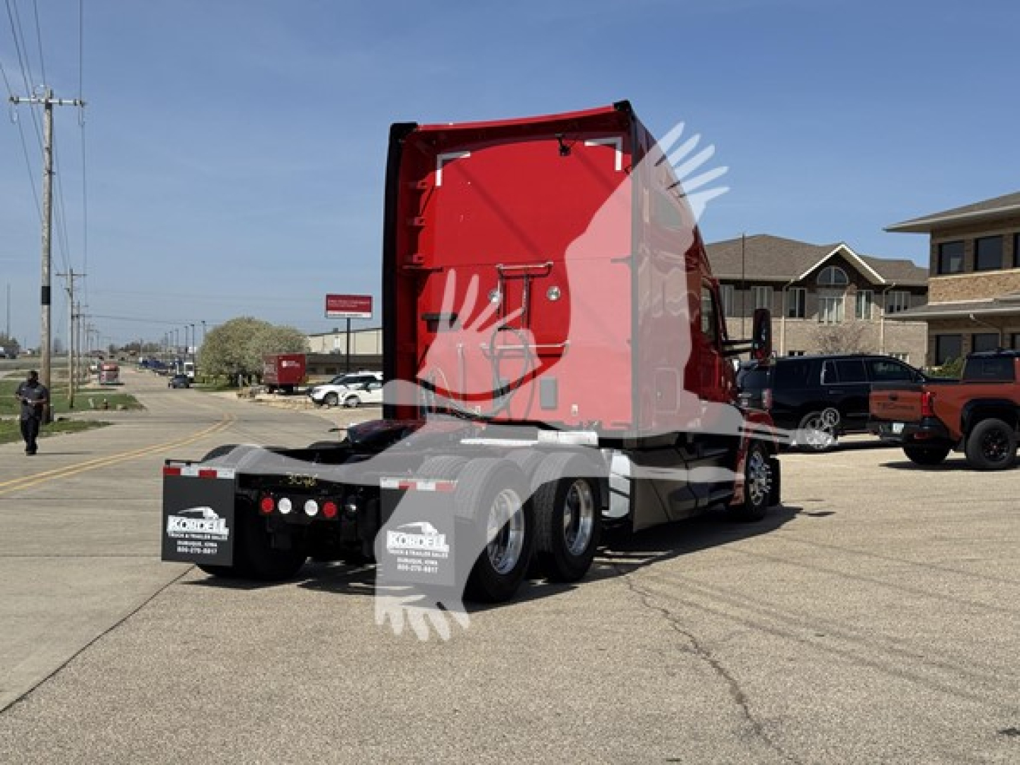 Kenworth T680 sleeper cab truck tractor rear view showing red sleeper cab and dual rear axles with chrome fuel tanks.