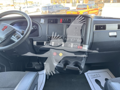 Dashboard and steering wheel of a 2022 Kenworth T680 cab interior with center control panel and cup holders.