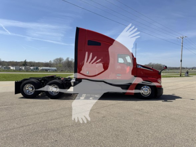 2022 Kenworth T680 side view showing tractor with red cab and sleeper, dual rear axles, chrome wheels.