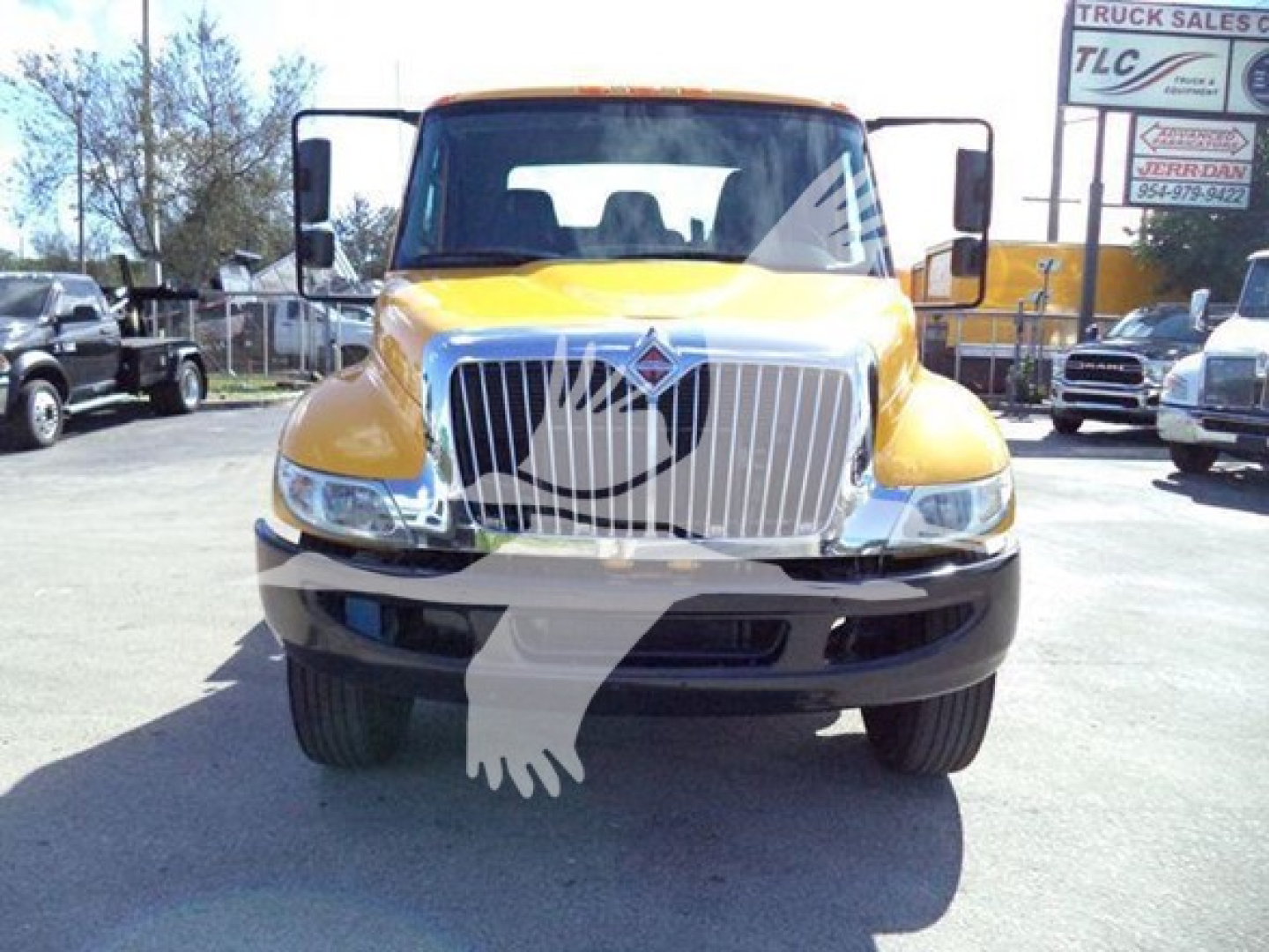 Front view of a yellow 2019 International Durastar 4300 rollback truck showing large chrome grille and headlights.