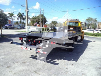 2019 International Durastar 4300 rollback tow truck with a flatbed, rear view showing rear lights and loading ramps, VIN plate area not legible.