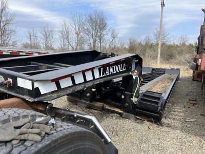 Landoll 326A lowboy trailer frame showing 'LANDOLL' logo and black steel beams with wheel chassis and tracked components