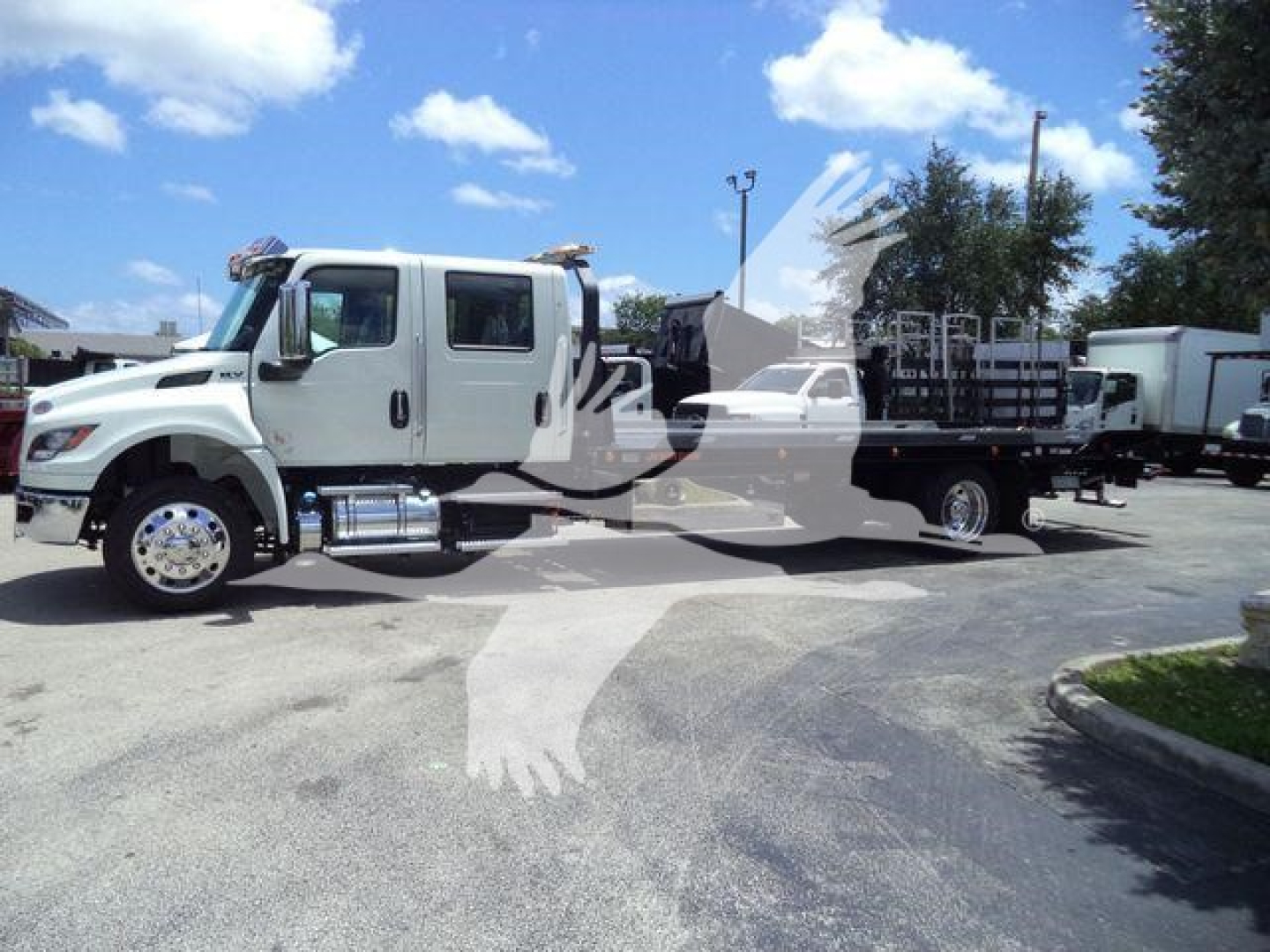 International MV truck in a dealership lot showing front and side view with long chassis and dual rear axles.