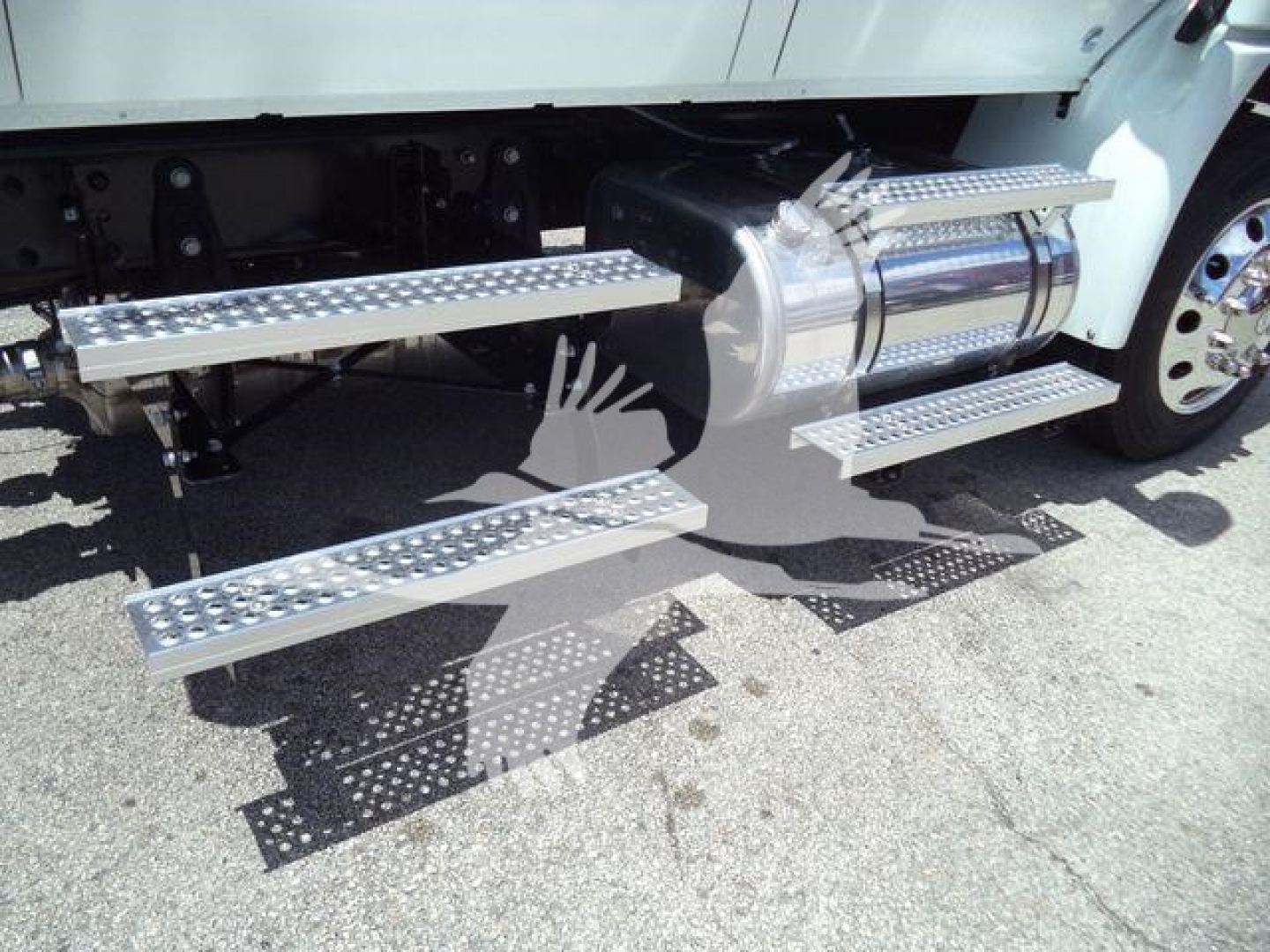 Truck with aluminum running boards and fuel tank visible, side steps with diamond tread pattern.
