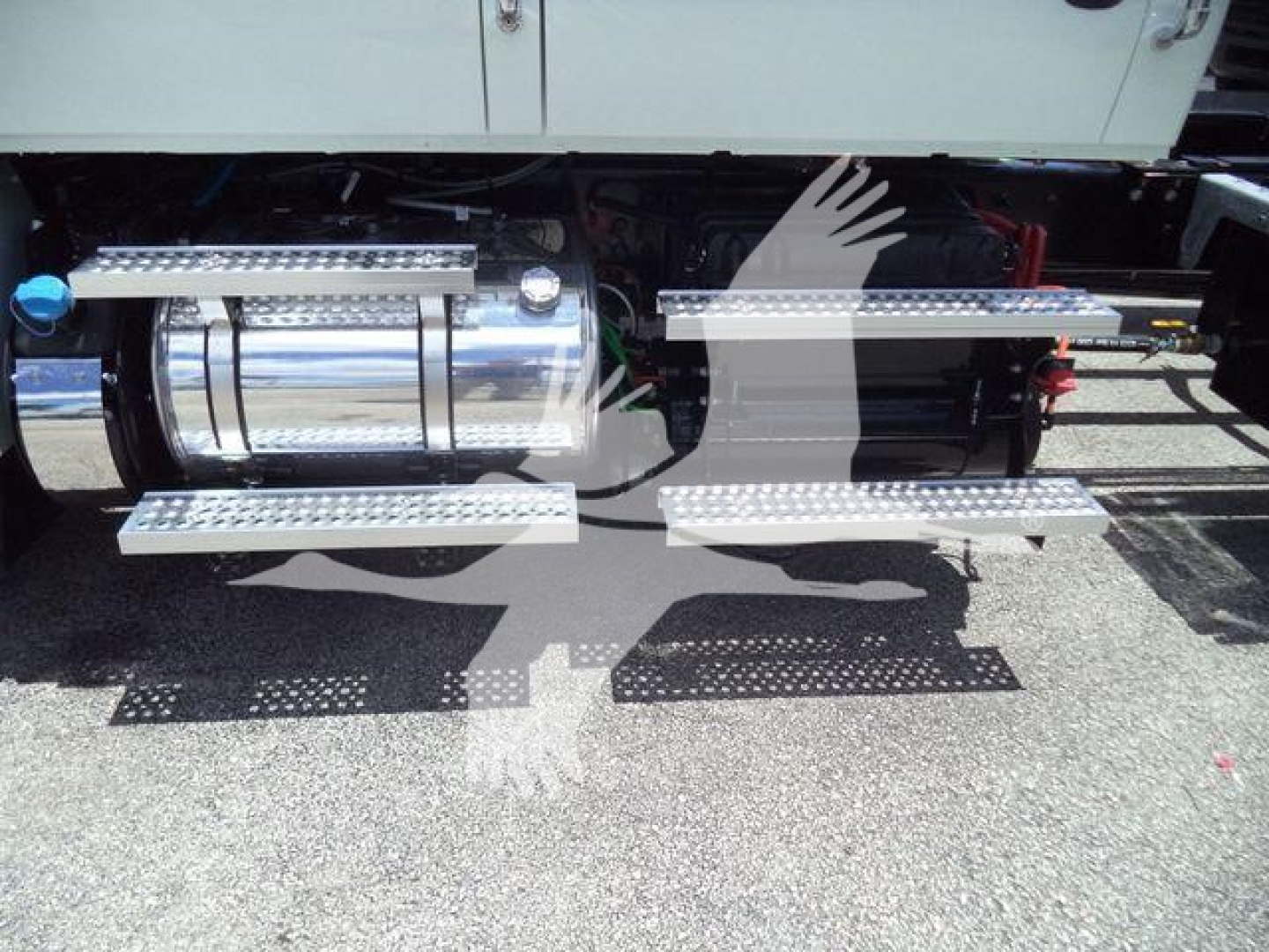 Truck undercarriage showing chrome fuel tank and side steps on International MV rollback truck.