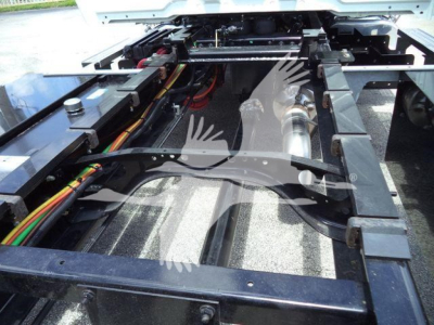 Trucks chassis frame with underbody components and wiring during service.