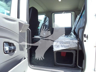 Truck cab interior showing front and rear seats with plastic covers and a window; view from open passenger door.
