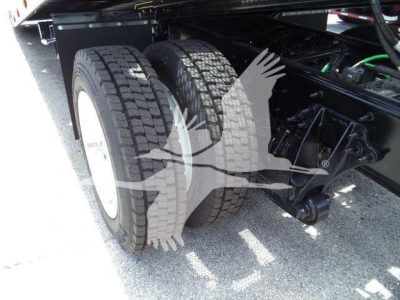 MV chassis showing dual rear tires and suspension components in a truck bed; rollover equipment visible with wheel twin tires and mechanical linkages.