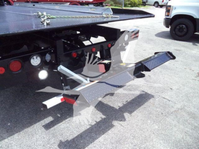Truck bed hitch and rear control platform of a 2026 International MV rollback truck showing a folded steel step and mounting hardware.
