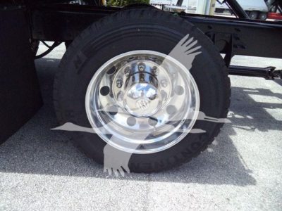 Truck wheel and tire on a rollback truck with a chrome hub and black tire