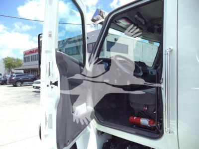 Truck cab interior and open door of a 2026 International MV with stock MVCREW22SRRD6T visible in a dealership lot.