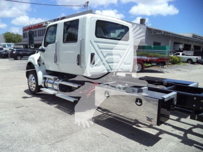 Truck cab of a new 2026 International MV rollback truck showing side view, with chassis and attachment frame.