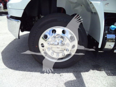 Truck front wheel and fender with chrome wheel, tire, and partial suspension components visible; discusses International MV series rollback truck.