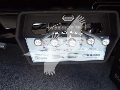 JerrDan towing winch control panel mounted under truck, with multiple switches and wiring visible.