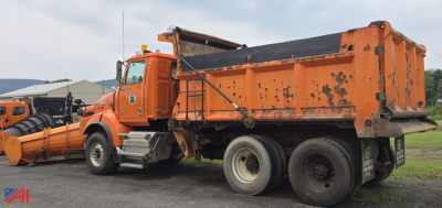 Dump truck with plow attachment showing side and rear of a 2012 Western Star 4900 SB in orange paint