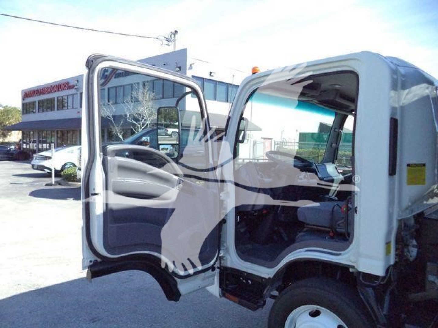 Isuzu NPR/NRR cab interior and opening driver door view showing steering wheel and dashboard