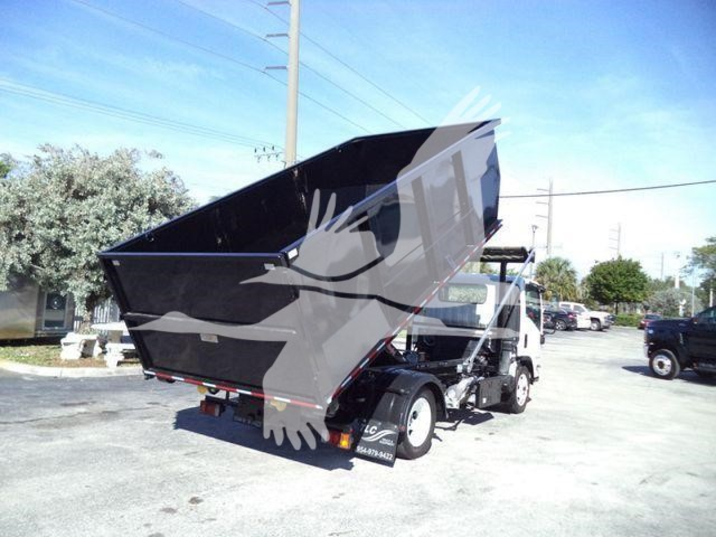 Isuzu NPRR/NRR roll-off truck with dumping container in raised position, side and rear view showing the cargo bed and chassis.