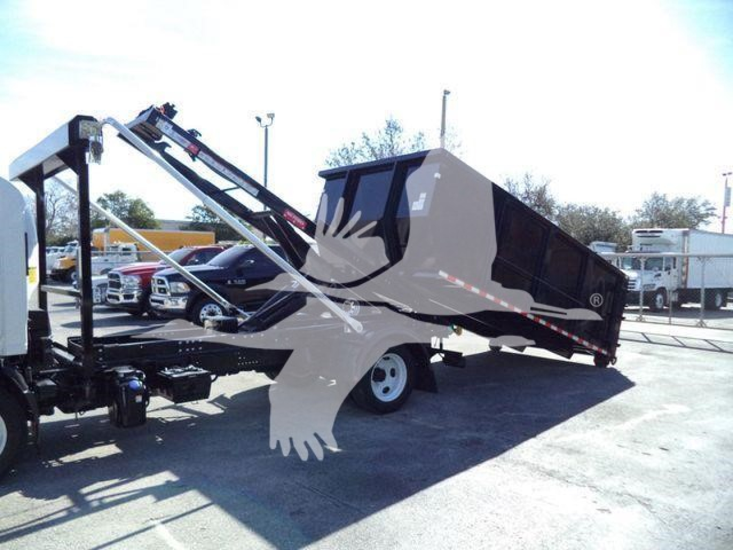Isuzu NPR/Nrr rolloff truck body in tilt position with loading crane and hydraulic system visible.