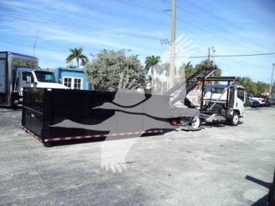 Isuzu NPRR roll-off truck with long black dumping bed and loading crane in a used-truck lot.
