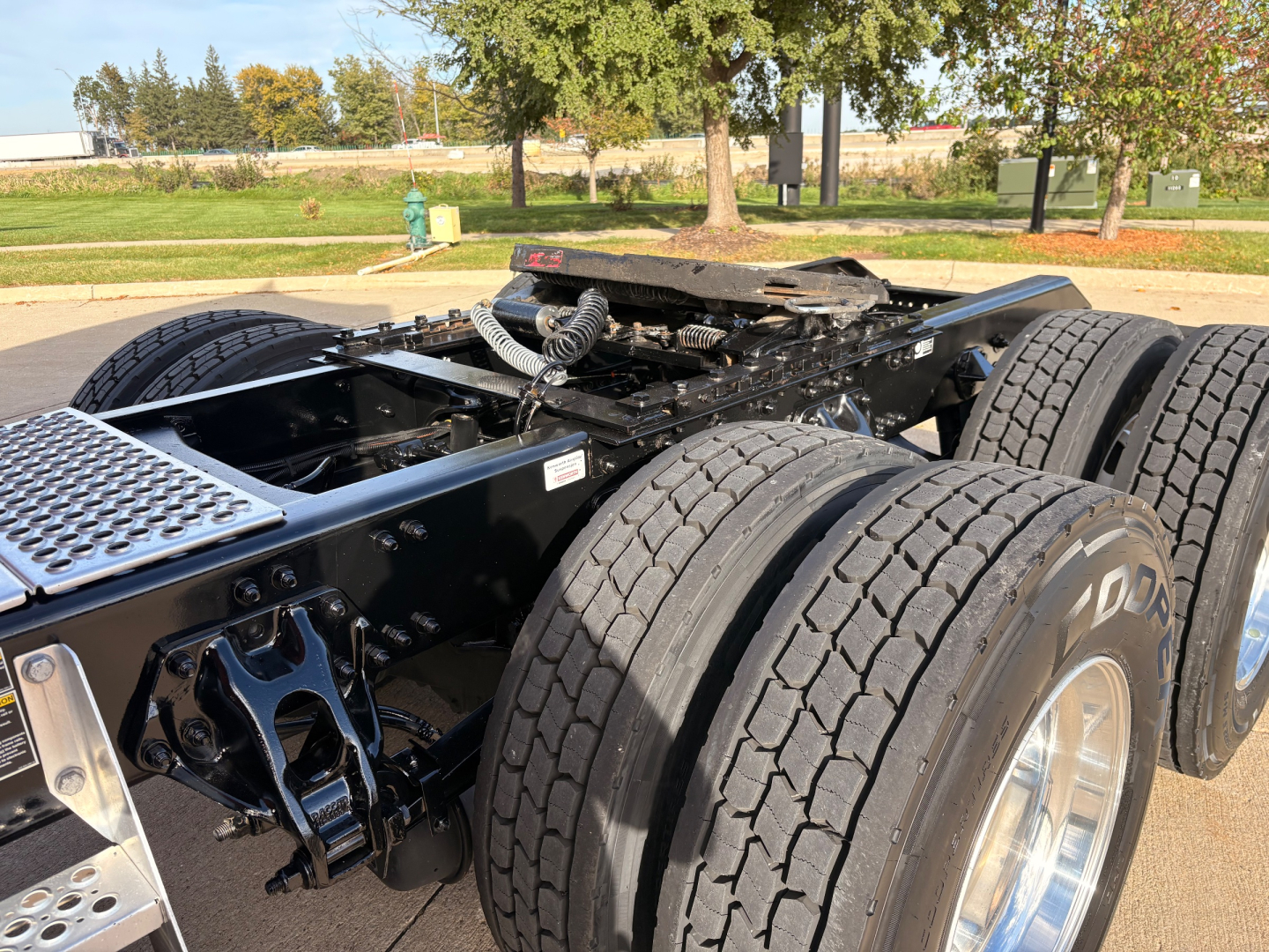 Kenworth T680 chassis with dual rear axles visible, components and tires in view. No visible text on the image itself.