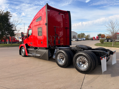 Kenworth T680 truck cab and chassis side view showing red sleeper cab and dual rear axles with chrome wheels.