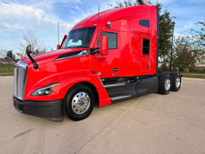 Kenworth T680 truck in red, side view showing cab and dual rear axles. No visible labels or sticker text readable on image.