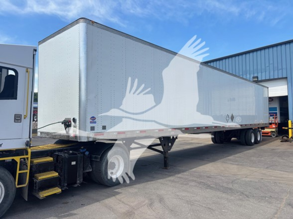 Trailer side view showing Utility 4000D-X trailer with aluminum body and tandem axle, clean and in service. Visible VIN and stock number notations in image area.