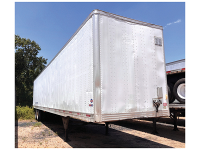 Utility 4000D-X trailer showing side and rear with riveted aluminum walls, tandem axles, front corner with jack and hitch, small decals near rear.