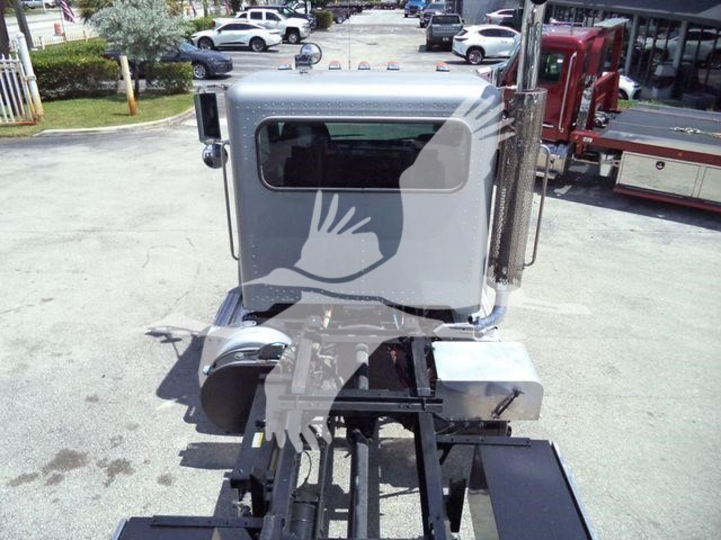 Peterbilt truck cab and rollback chassis showing front view with grey cab and attached hydraulic components.