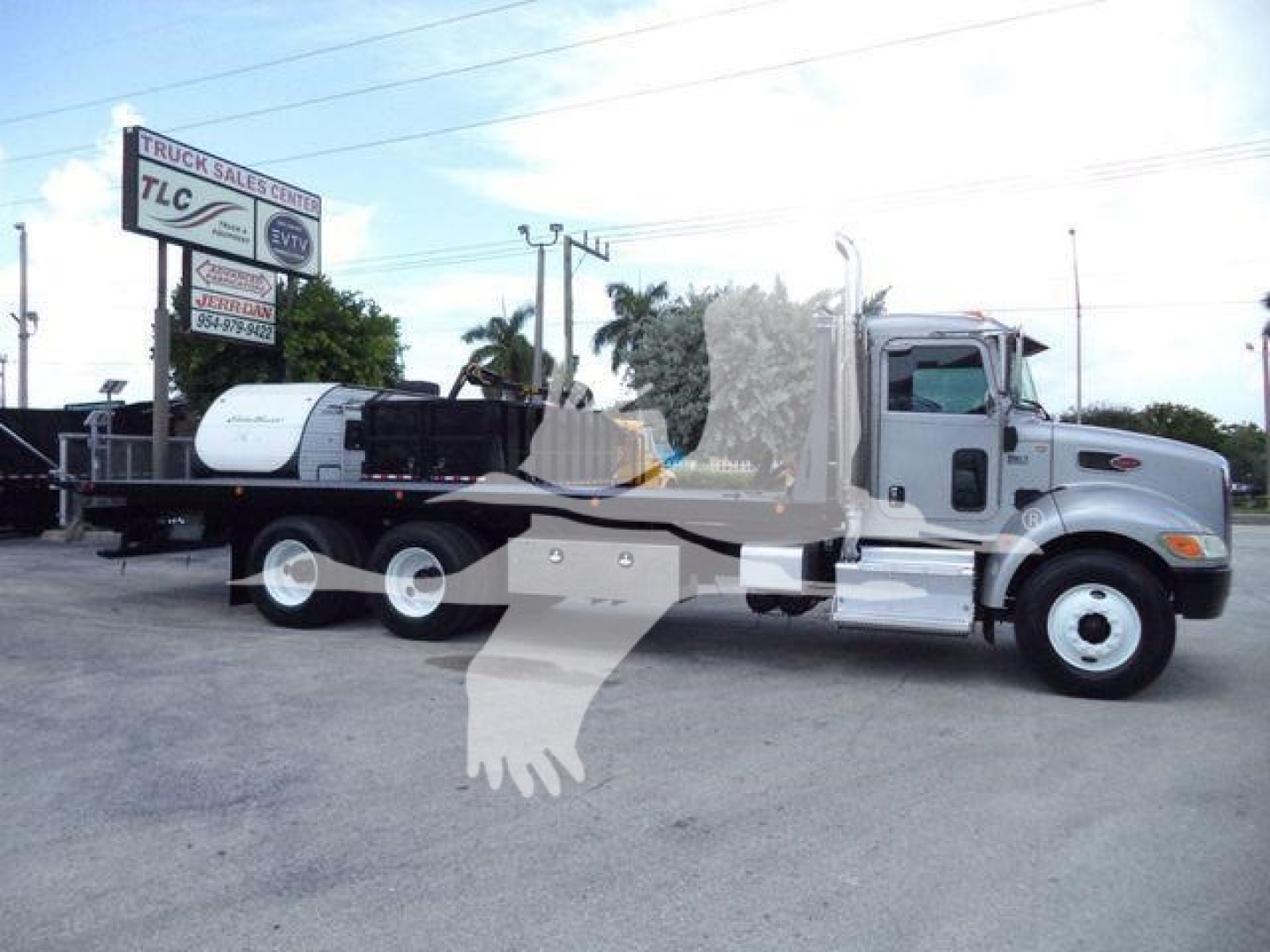 Peterbilt 348 rollback truck with cab and flatbed, side view; includes text signs in background but focus on truck.