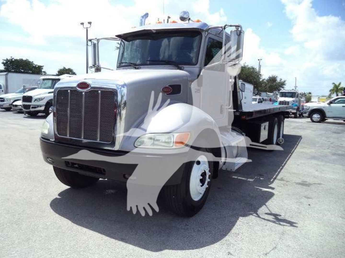 Peterbilt 348 tow truck / rollback in service with front grille, chrome bumper, dual headlights, white cab, long flatbed with wheel-lift equipment visible.