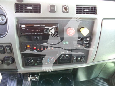 Peterbilt 348 dashboard center panel with radio and control switches, dashboard vents, knobs, and gauges visible.