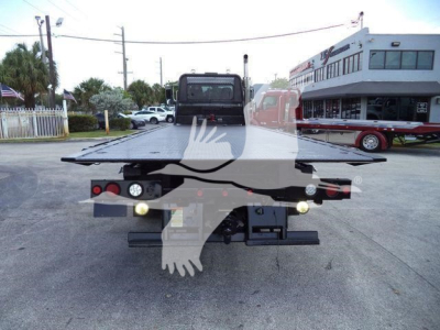 Truck bed with flatbed rollback apparatus and taillights visible from rear, Peterbilt 348 style chassis in background.