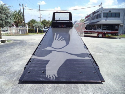 Peterbilt 348 rollback flatbed truck showing hydraulic gooseneck and rear deck with a dove graphic on the bed