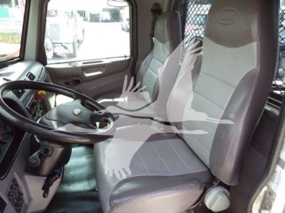 Peterbilt truck cab interior showing driver seat and passenger seat with steering wheel and dashboard visible.
