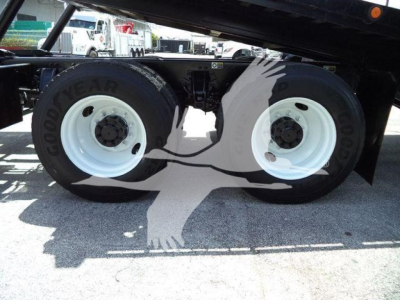 Peterbilt 348 rollback truck dual rear wheels showing Goodyear tires and white rims under a raised bed.